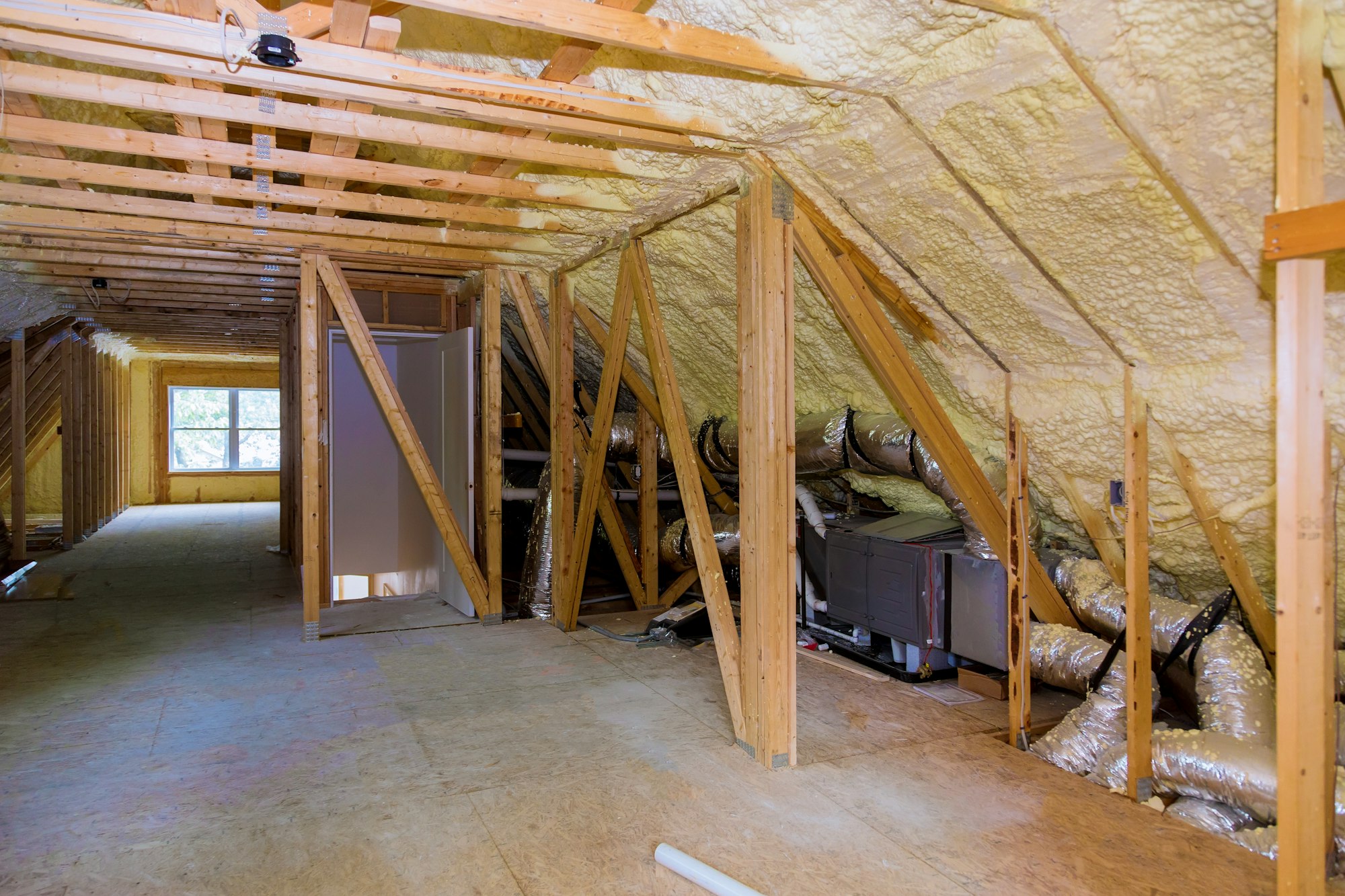 Foam plastic insulation installed in the sloping attic of a new frame house.