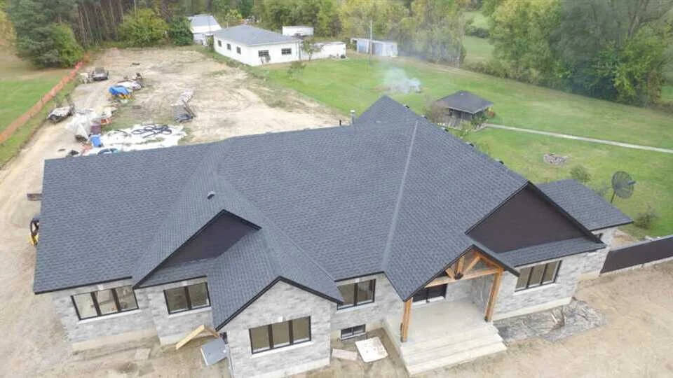 New residential installation showcasing roofing in Ancaster using GAF Timberline HDZ shingles in charcoal, with coordinated black soffit, fascia, and eavestrough. Ideal example of clean new construction work.